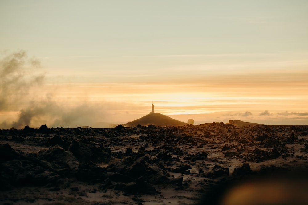 the sun is setting over a rocky area