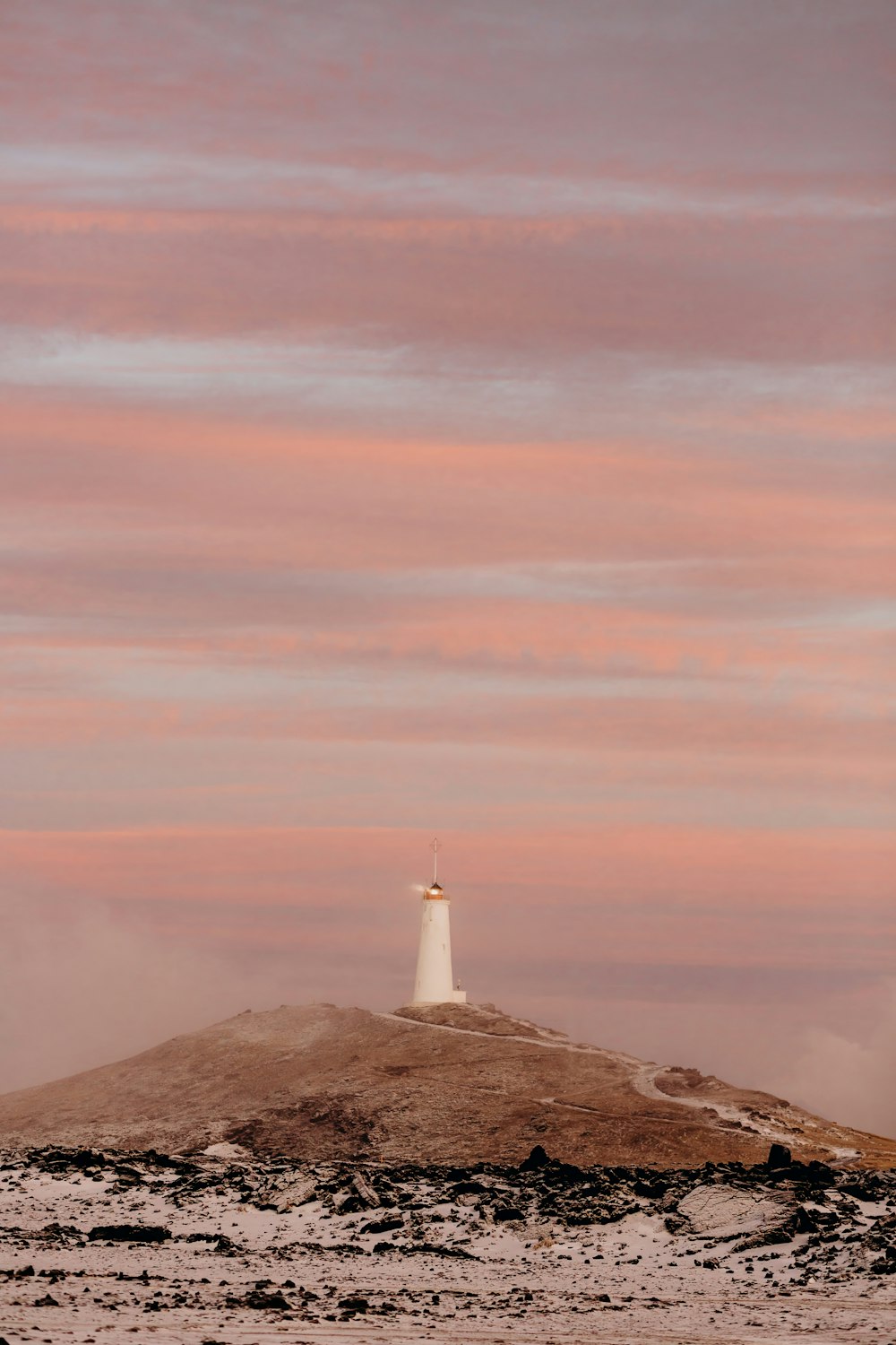 a lighthouse on a small island in the middle of the ocean