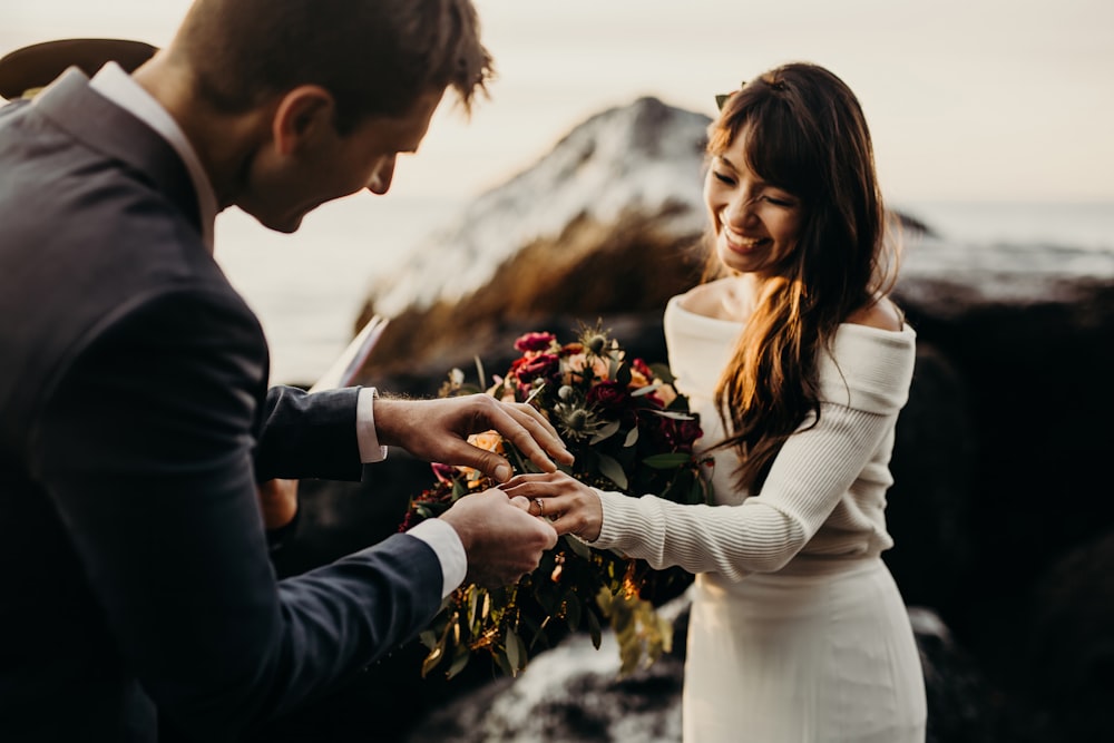 um homem e uma mulher trocando uma aliança de casamento