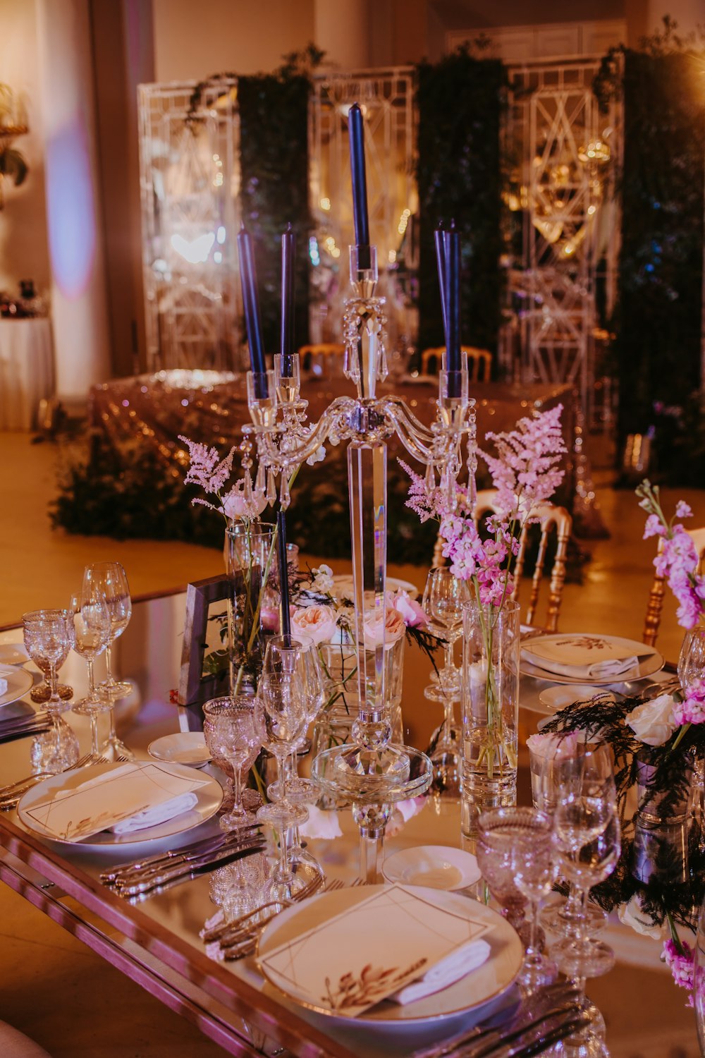 a table set for a formal dinner with flowers and candles