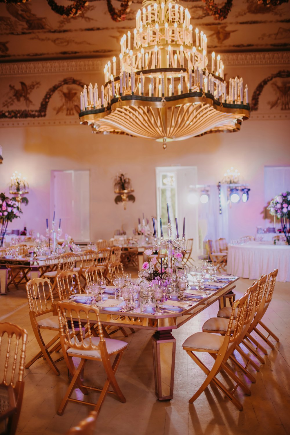 a dining room with a chandelier and tables