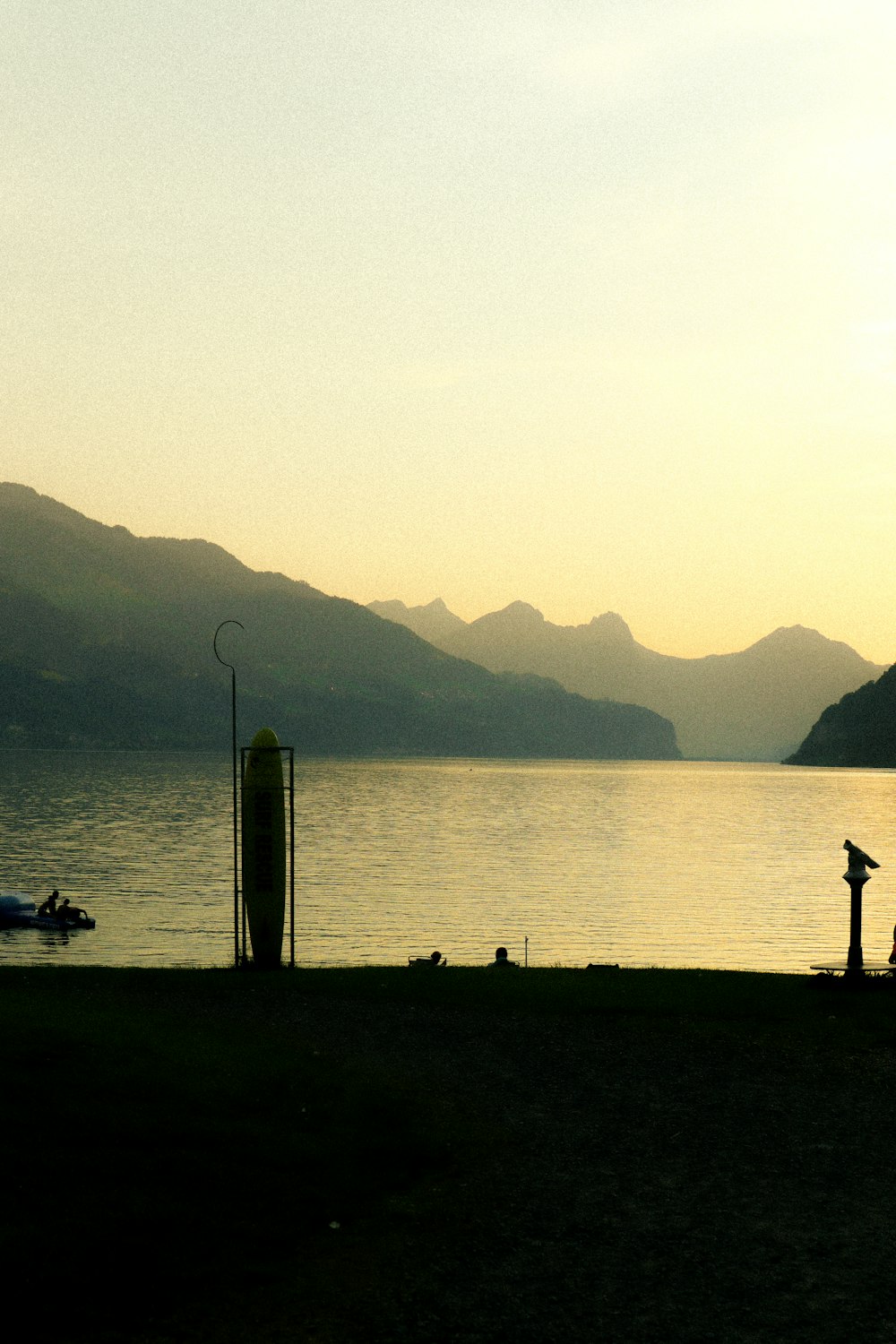 a couple of people standing next to a body of water