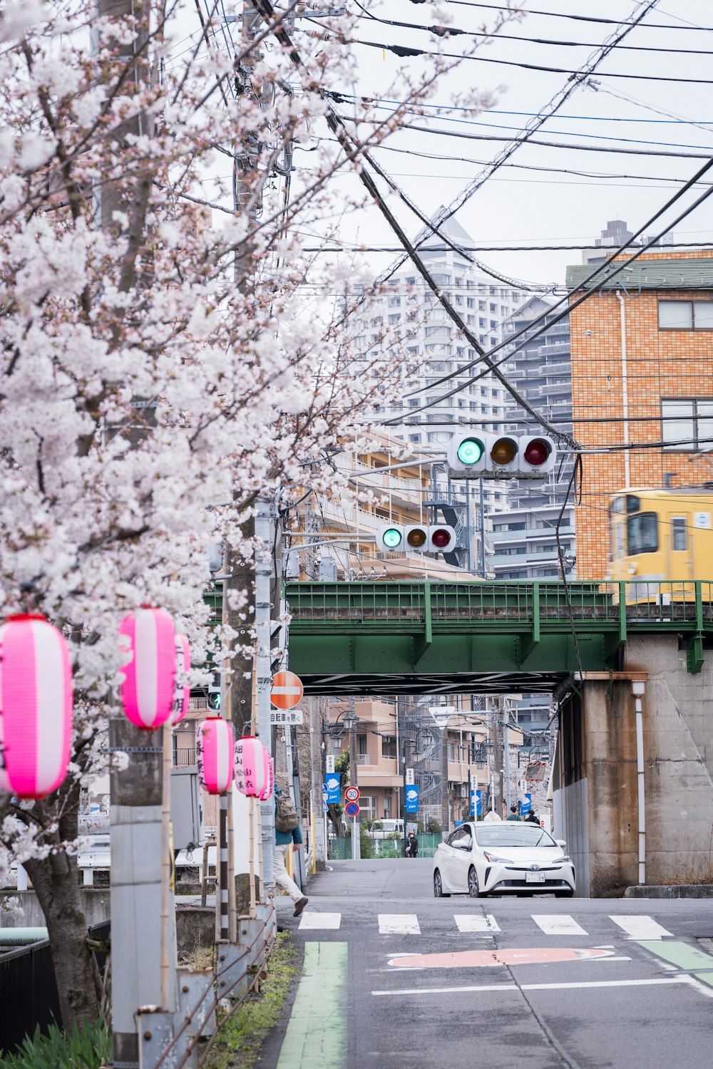 a car driving down a street under a bridge