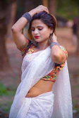 a woman wearing a white sari and a colorful blouse