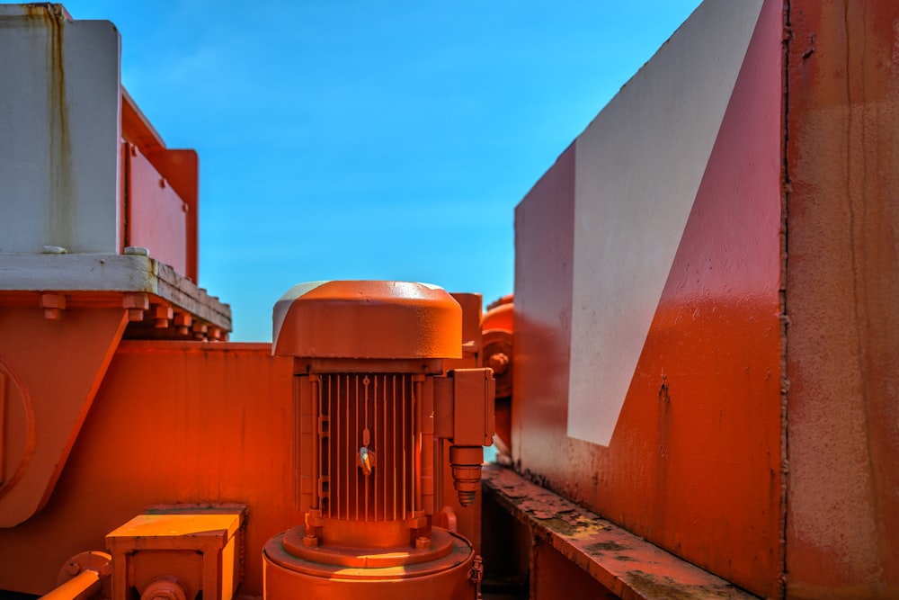eine große orangefarbene Maschine, die neben einem Gebäude steht