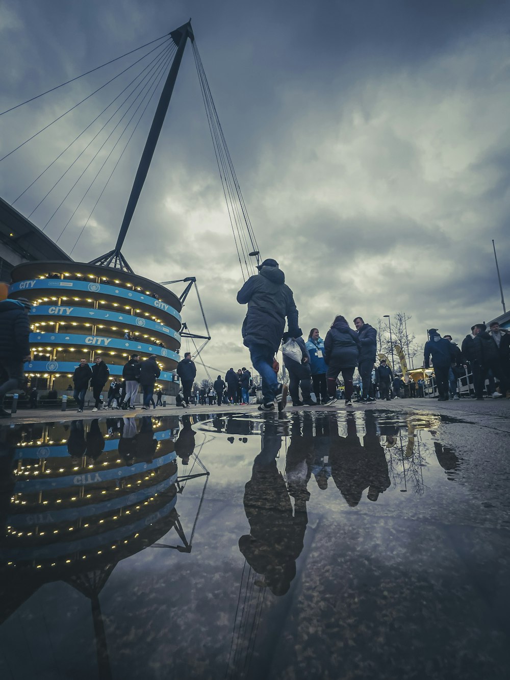 a group of people standing on top of a wet ground