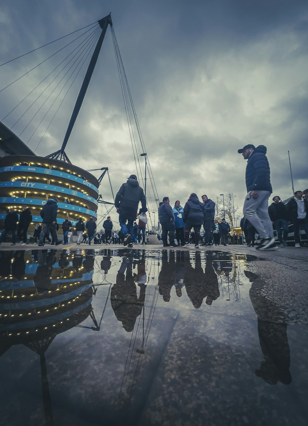 a group of people standing on top of a wet ground