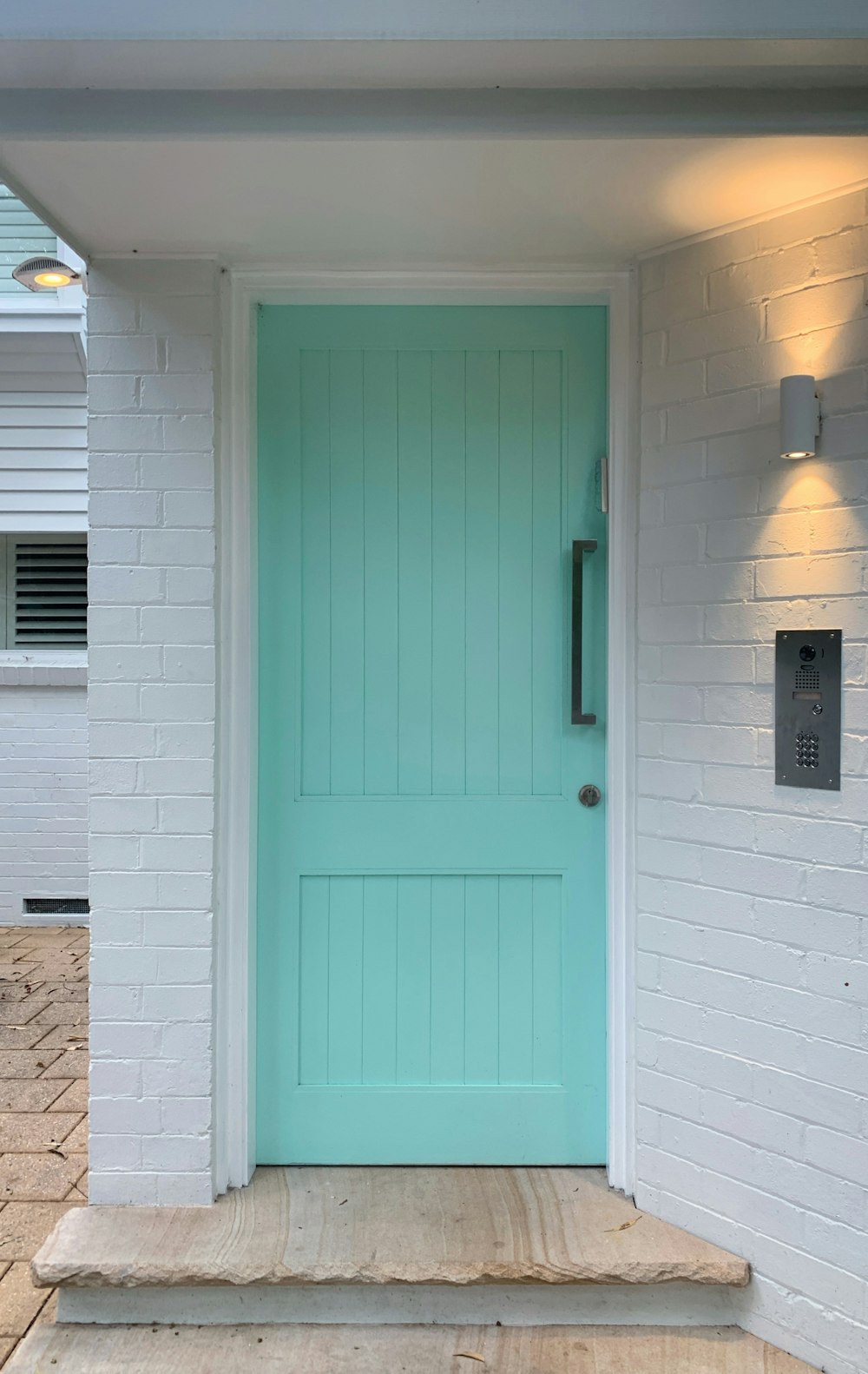 a blue front door on a white brick house