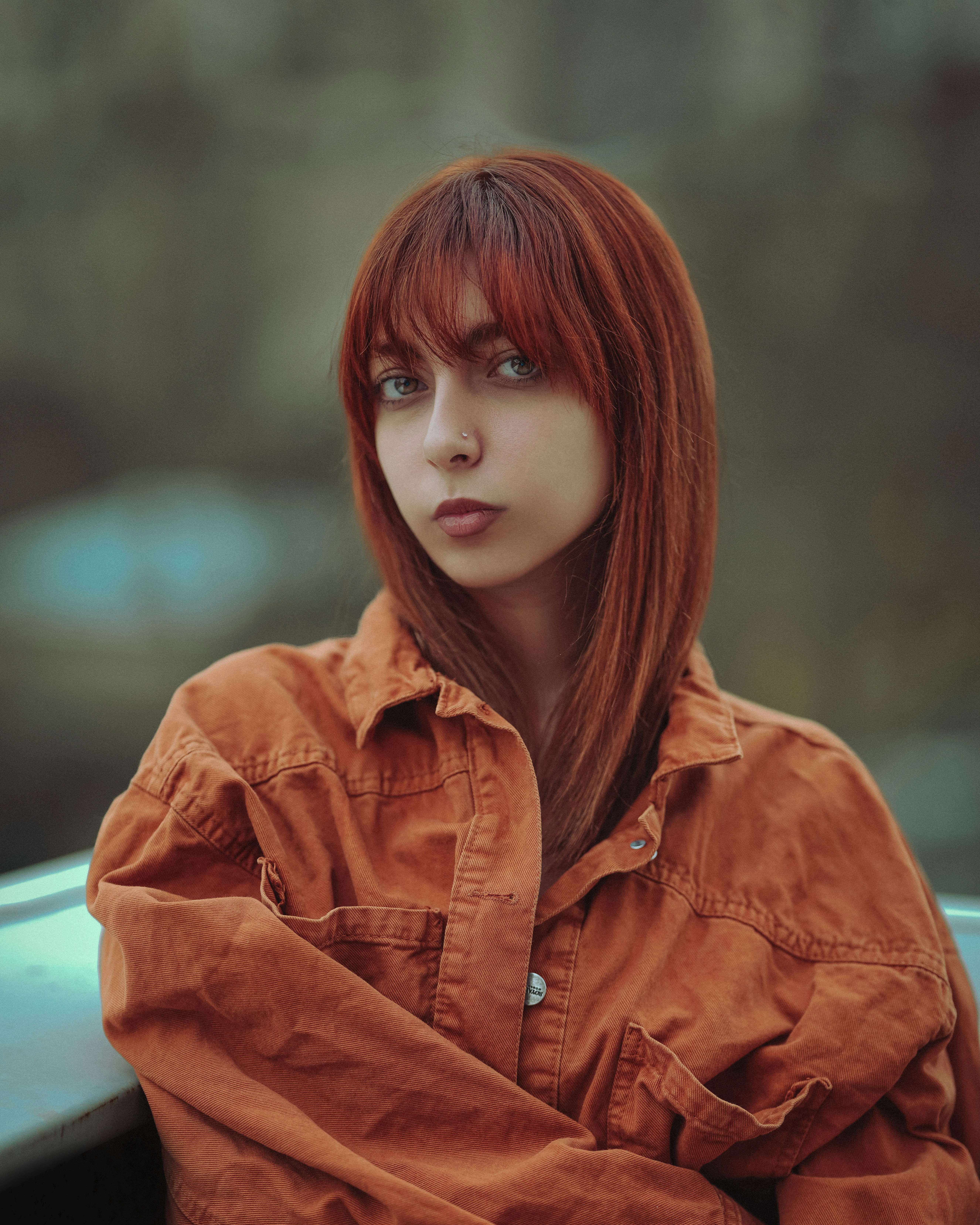 a woman with red hair is leaning on a car