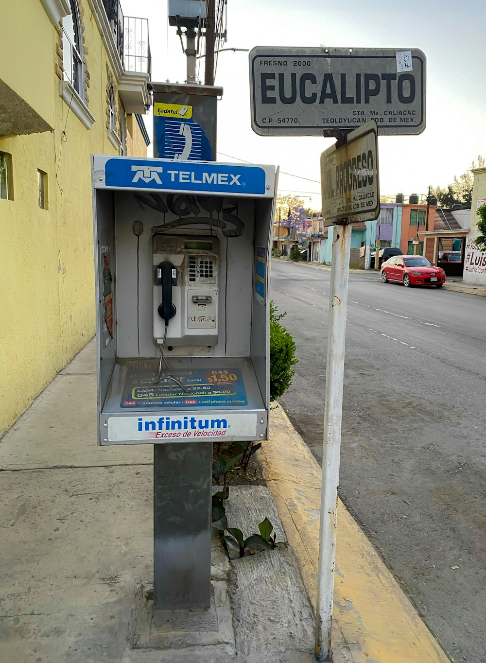 an old fashioned pay phone on the side of the street