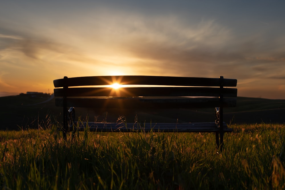 a bench sitting on top of a lush green field