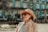 a woman wearing a tan hat and sunglasses