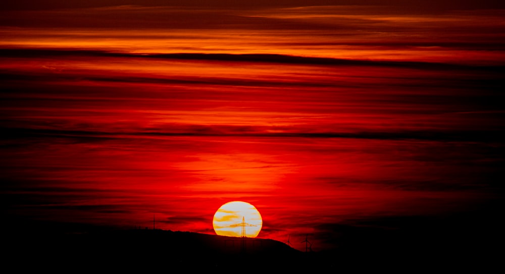 the sun is setting over the horizon of the ocean