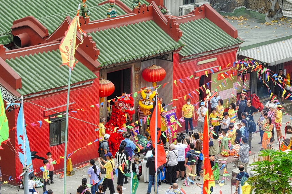 a group of people standing outside of a red building