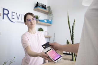 a woman is handing a card to a man