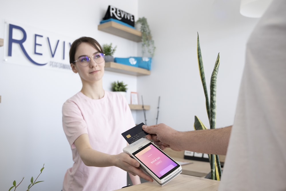 a woman is handing a card to a man