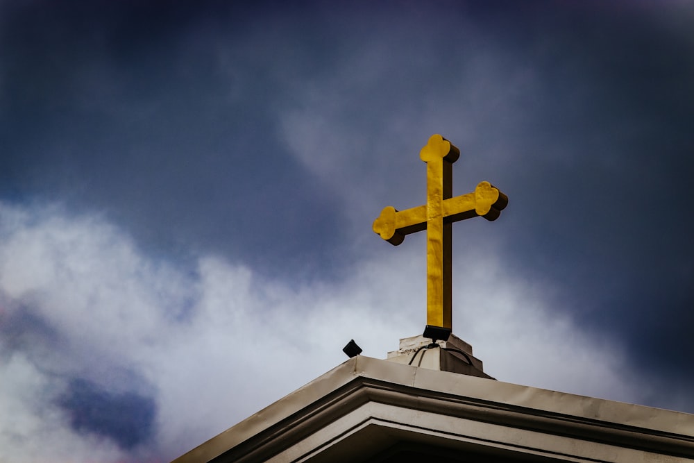 uma cruz amarela no topo de um edifício