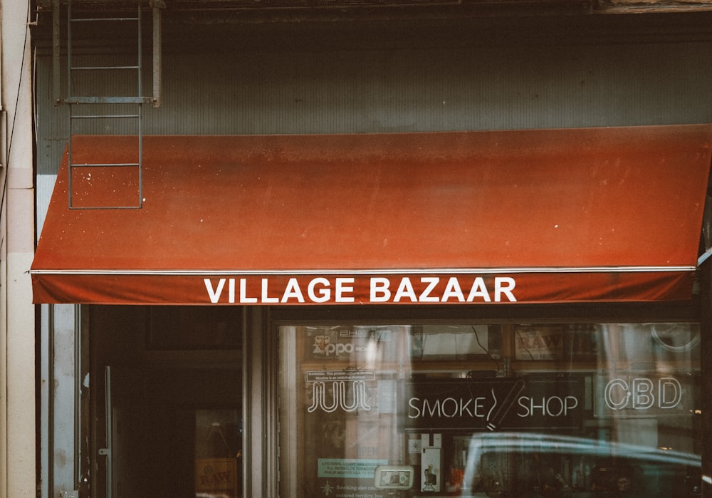 a store front with a red awning over it