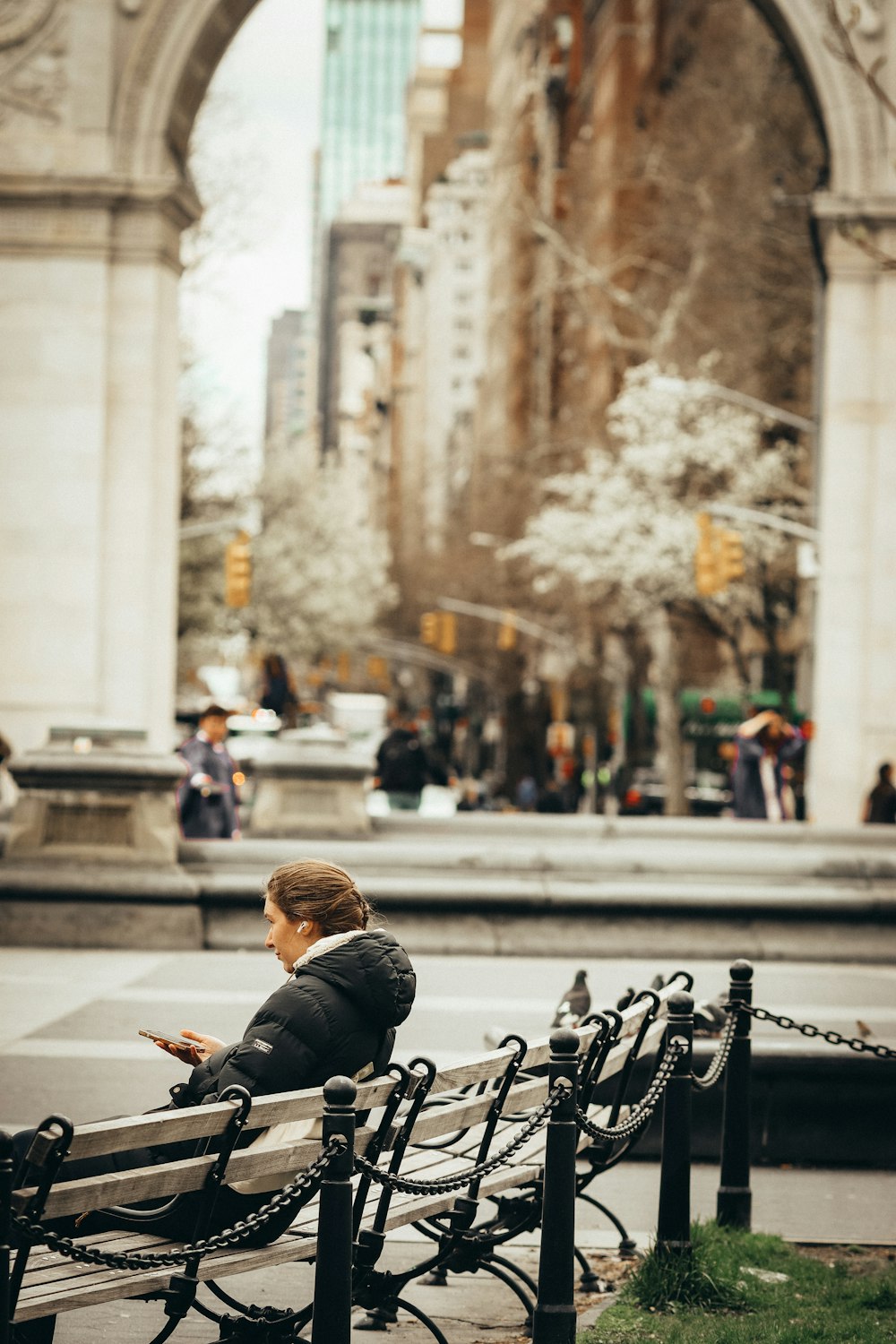 eine Person, die mit einem Handy auf einer Bank sitzt