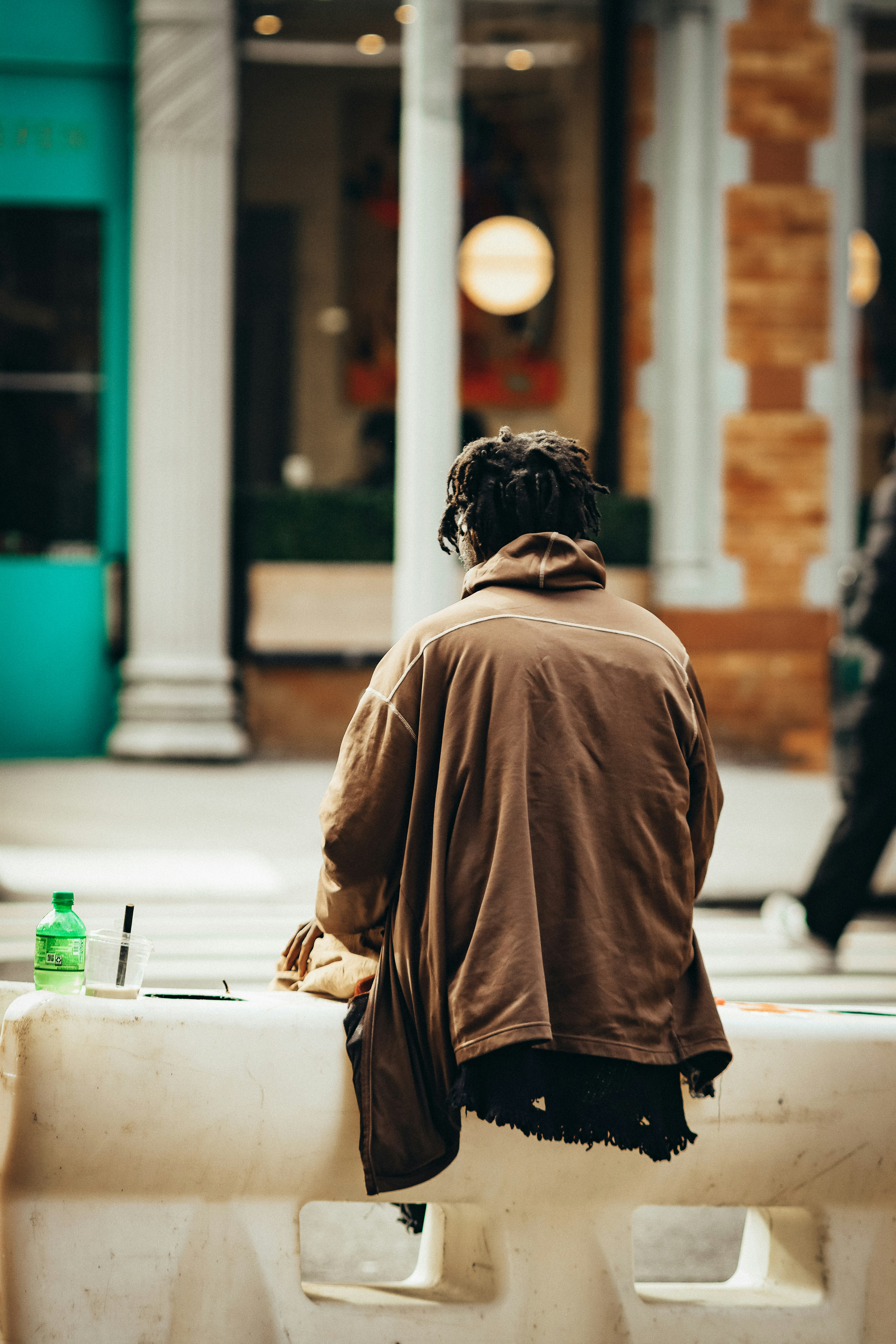 a person sitting on a bench in front of a building