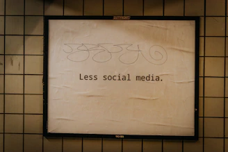 a sign on a wall that says less social media