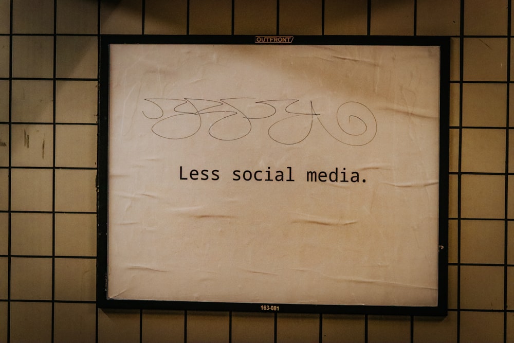 Ein Schild an einer Wand, auf dem weniger Social Media steht