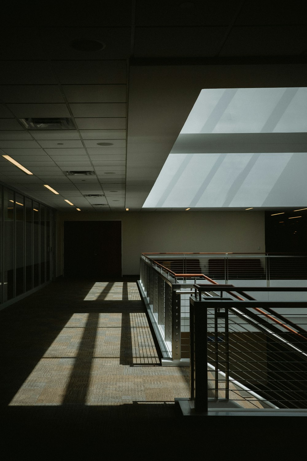 a long hallway with a railing and windows