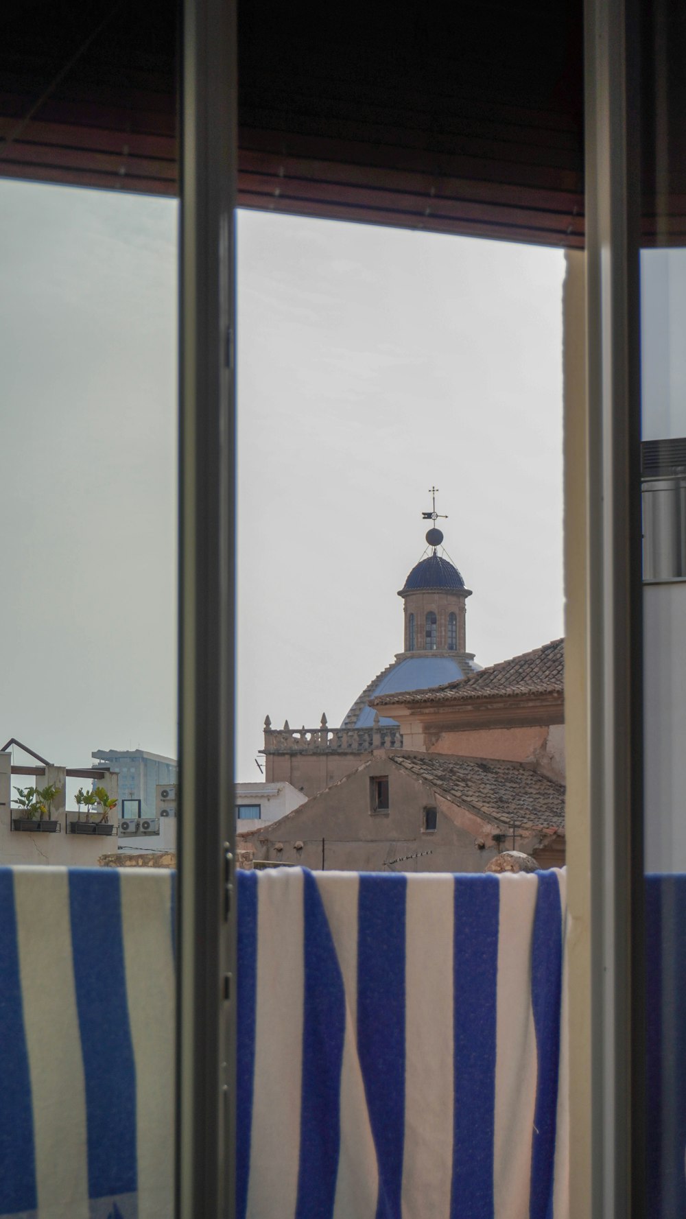 a view out a window of a building with a clock tower in the background