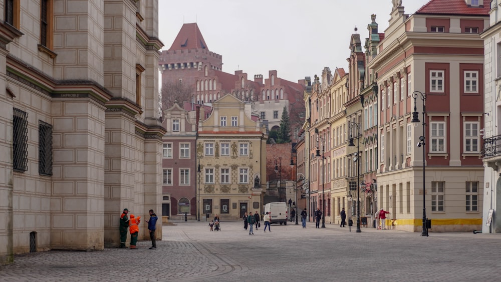 a group of people walking down a street next to tall buildings