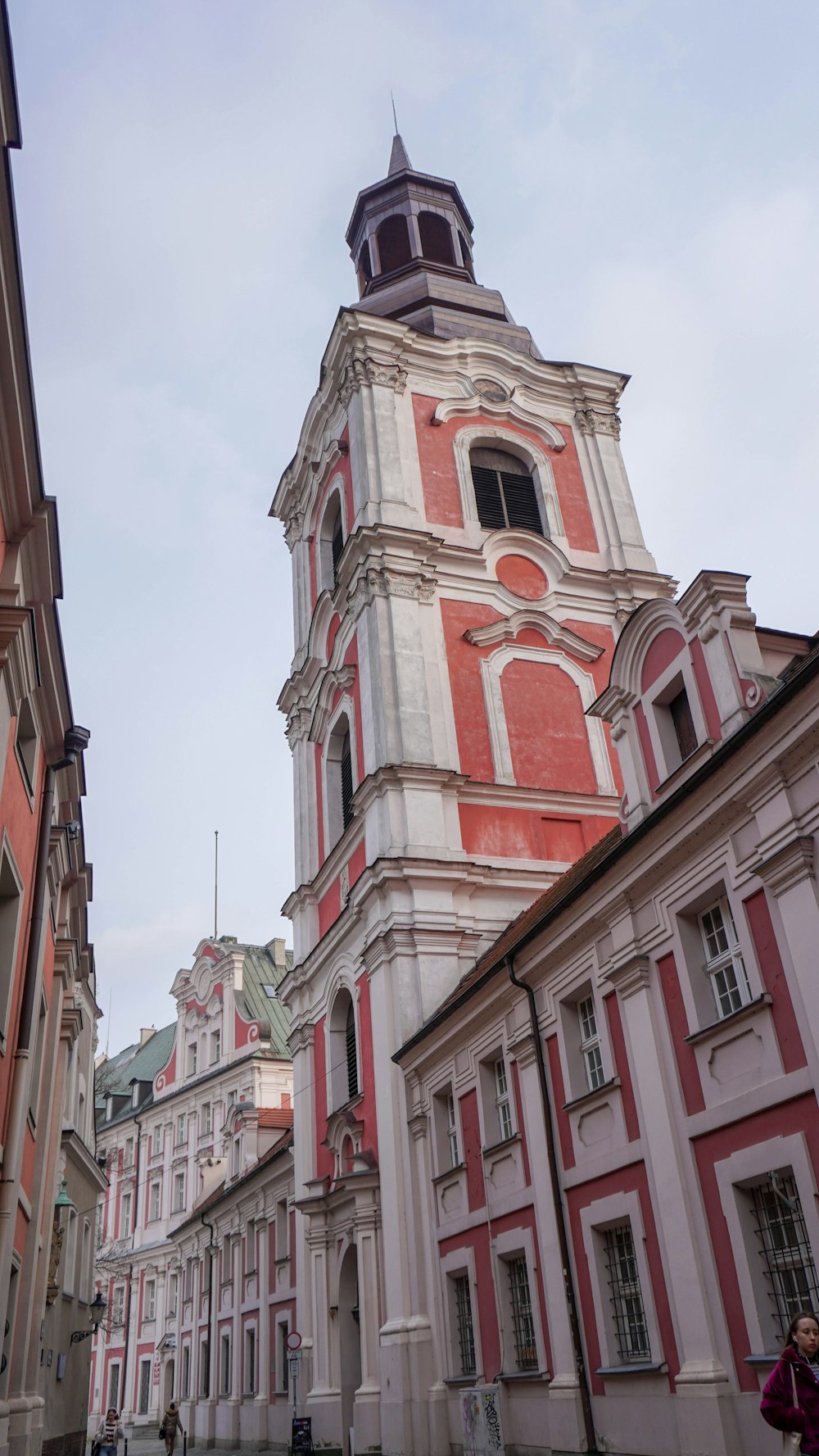 a tall red and white building with a clock tower