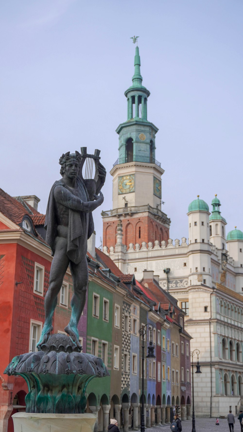 a statue of a man holding a harp in front of a building