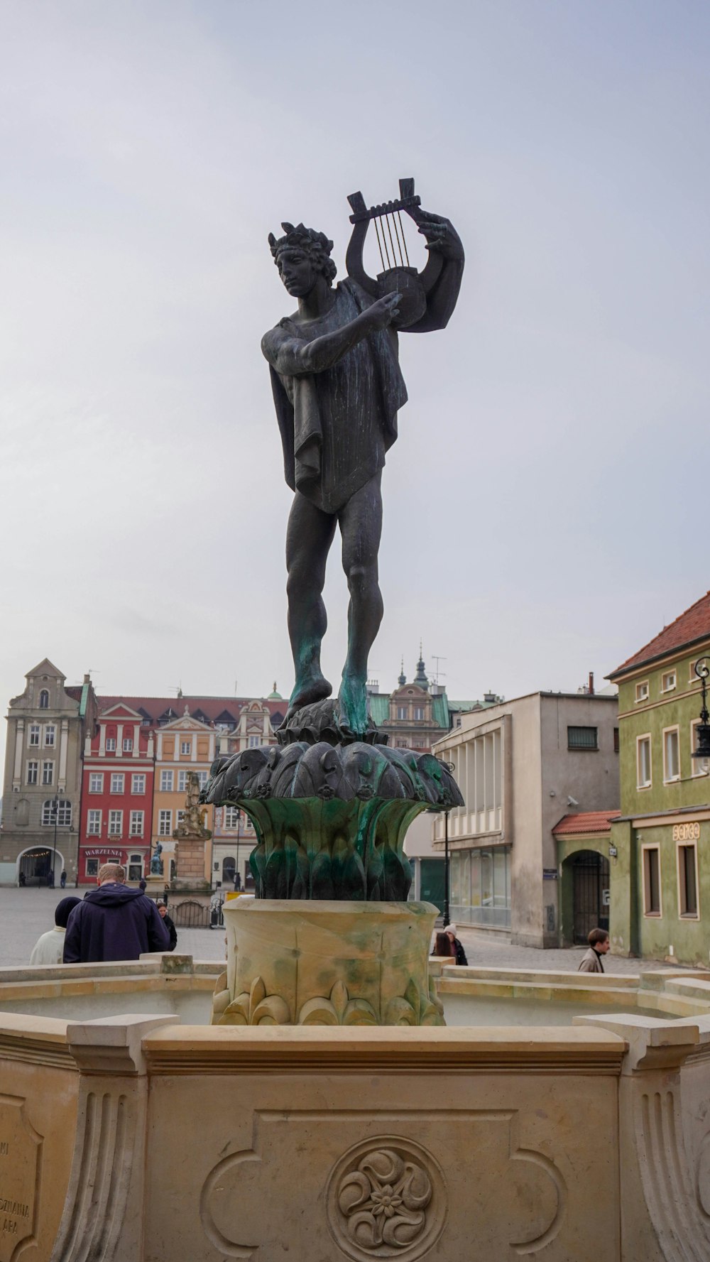 a statue of a man holding a harp