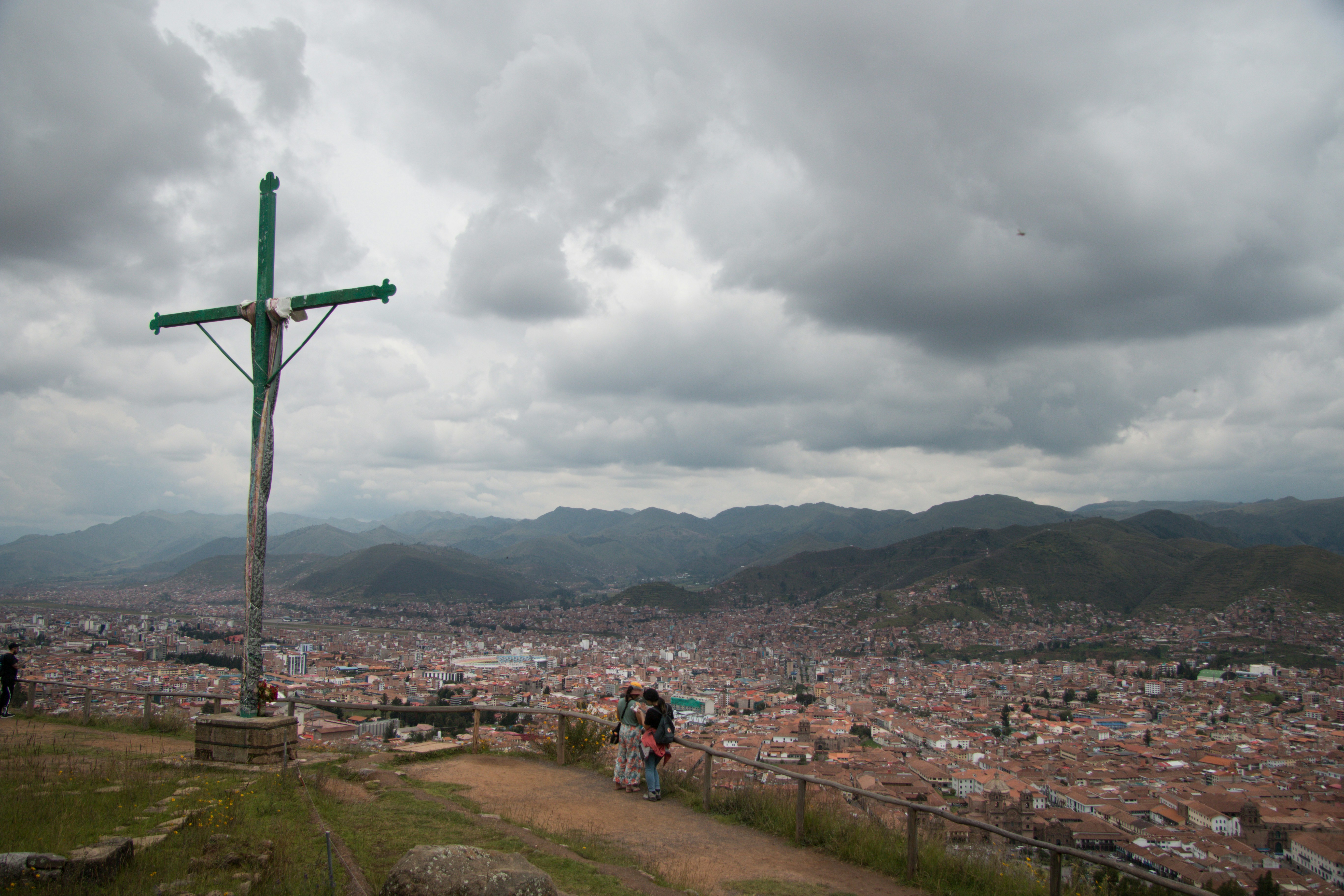 a cross on top of a hill overlooking a city