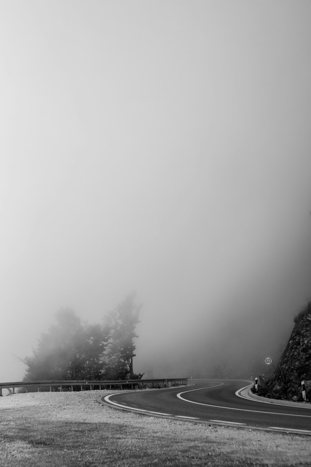 a foggy day on a winding road in the mountains
