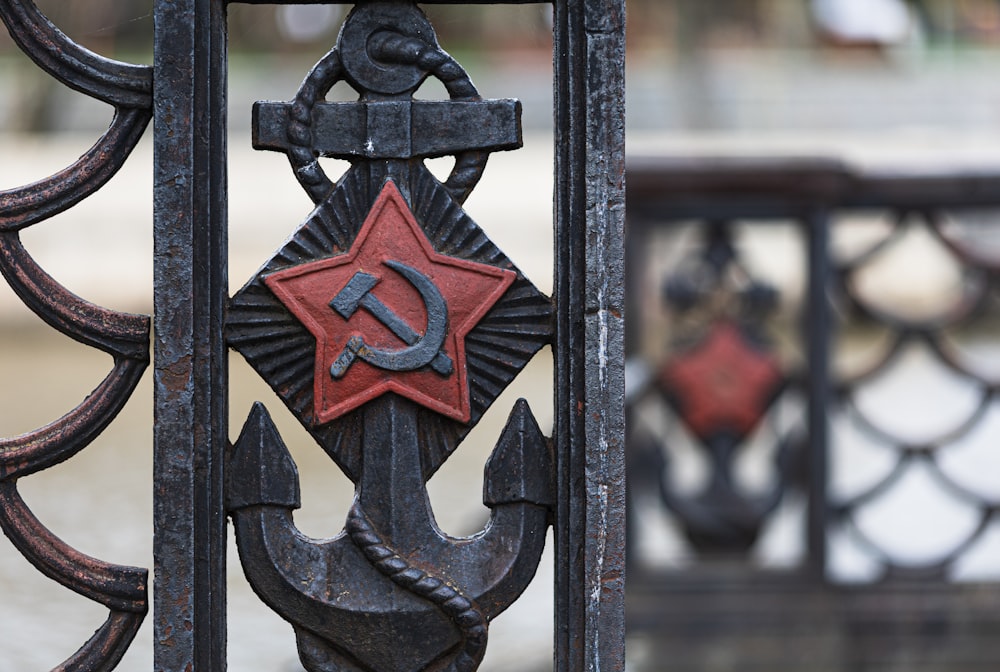a close up of a metal fence with a hammer and sick symbol