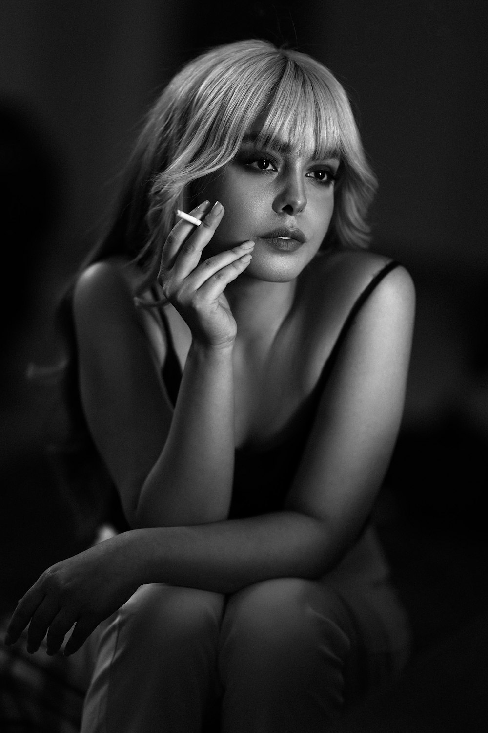 a black and white photo of a woman smoking a cigarette