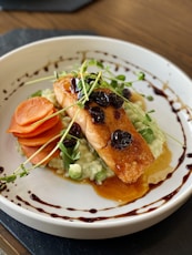 a white plate topped with fish and veggies