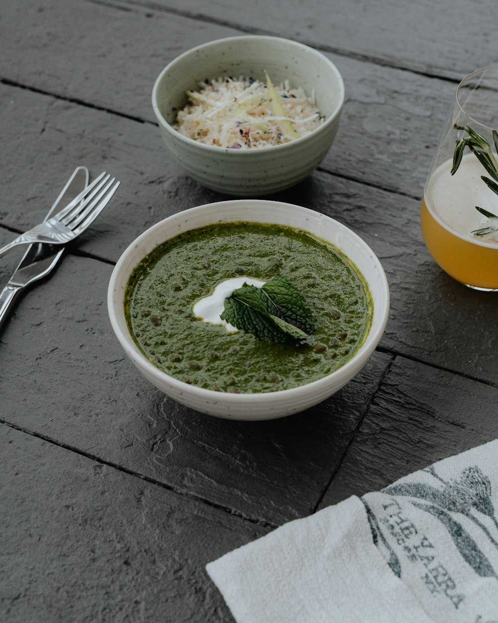 a bowl of soup next to a glass of orange juice