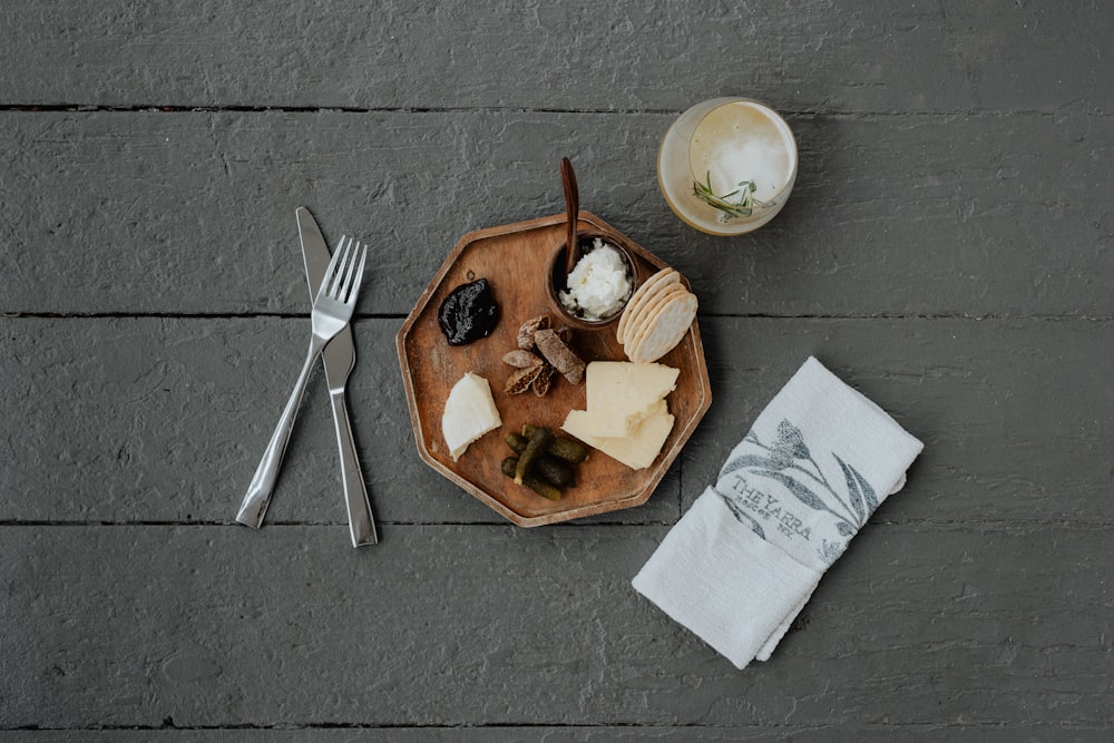 a wooden plate topped with cheese and crackers