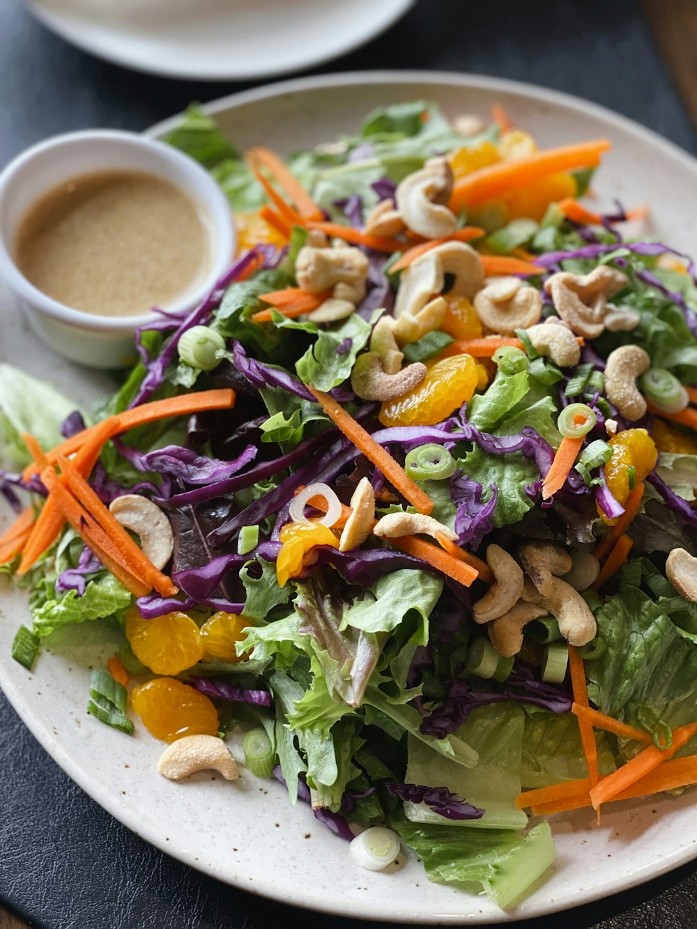 a white plate topped with a salad and dressing