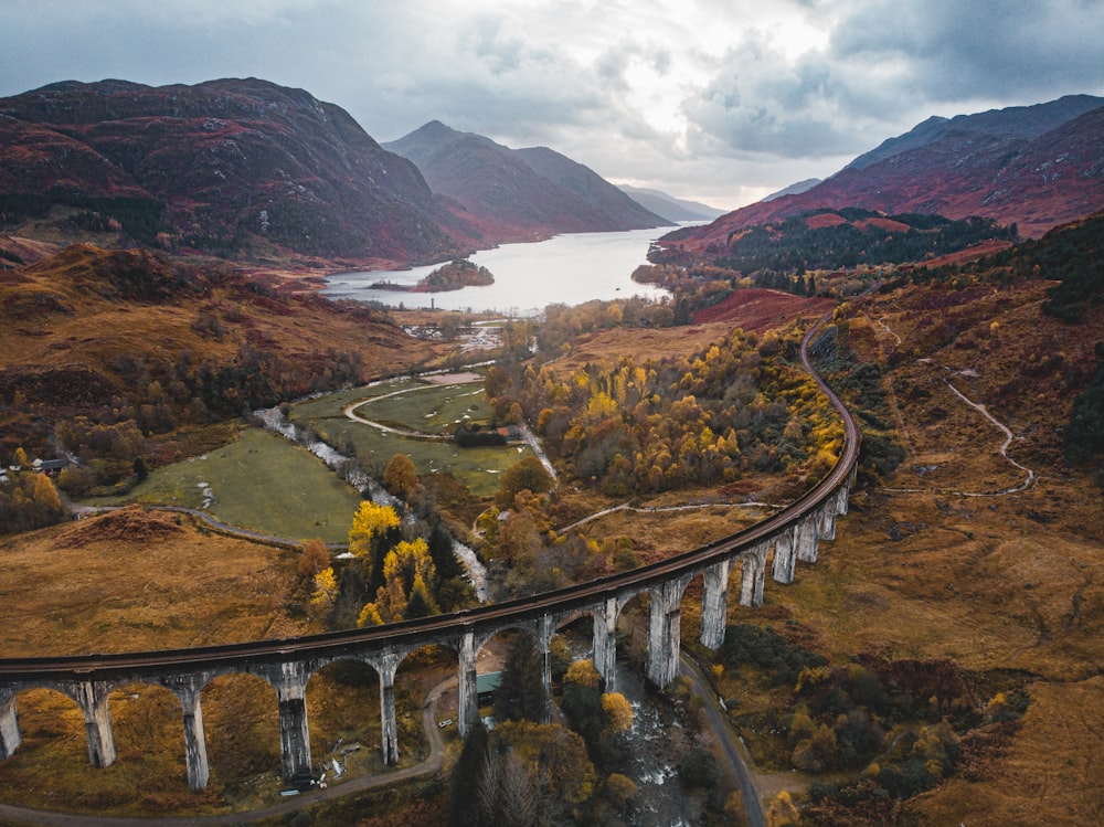 an aerial view of a train traveling over a bridge