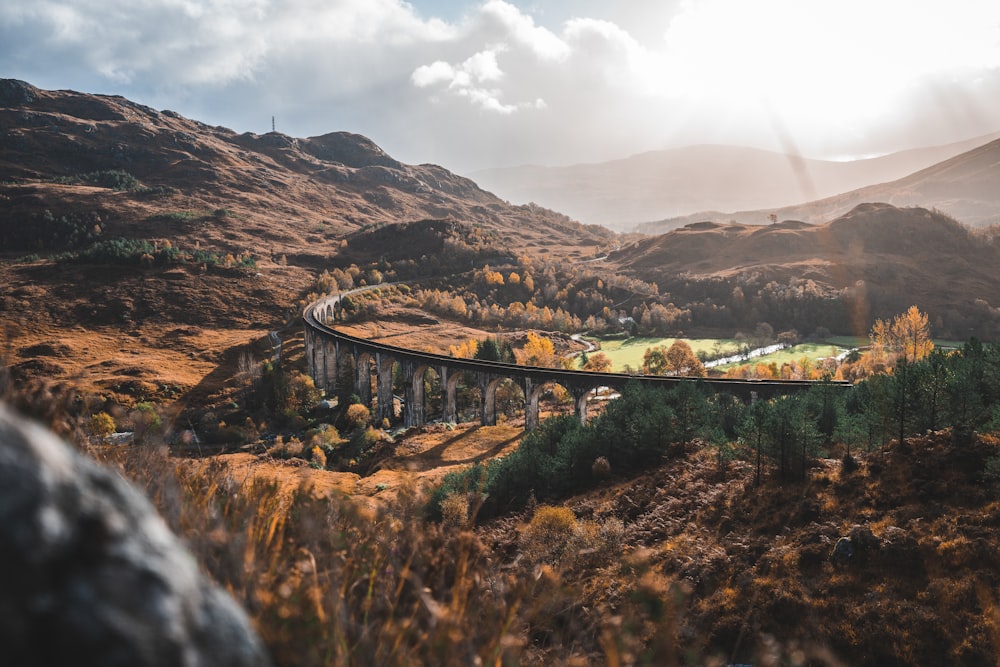 a train traveling over a bridge in the mountains