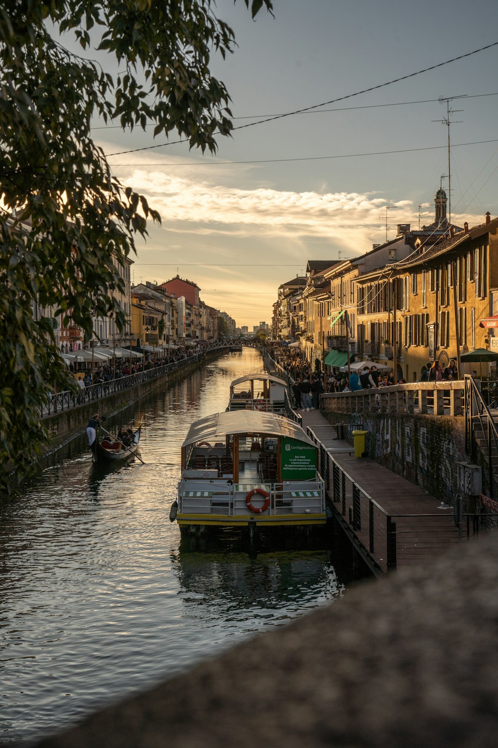 a boat traveling down a river next to tall buildings