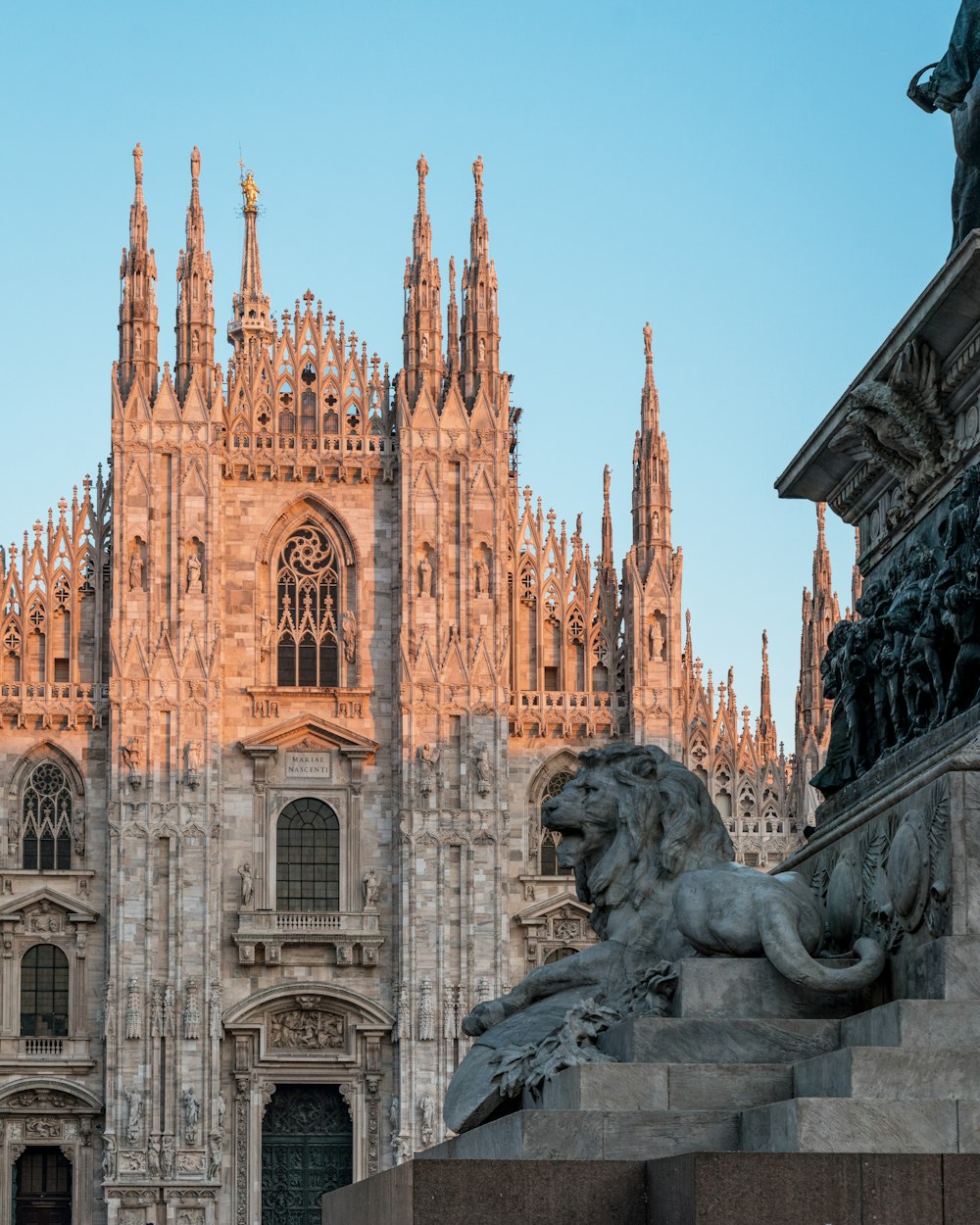 a statue of a lion in front of a cathedral