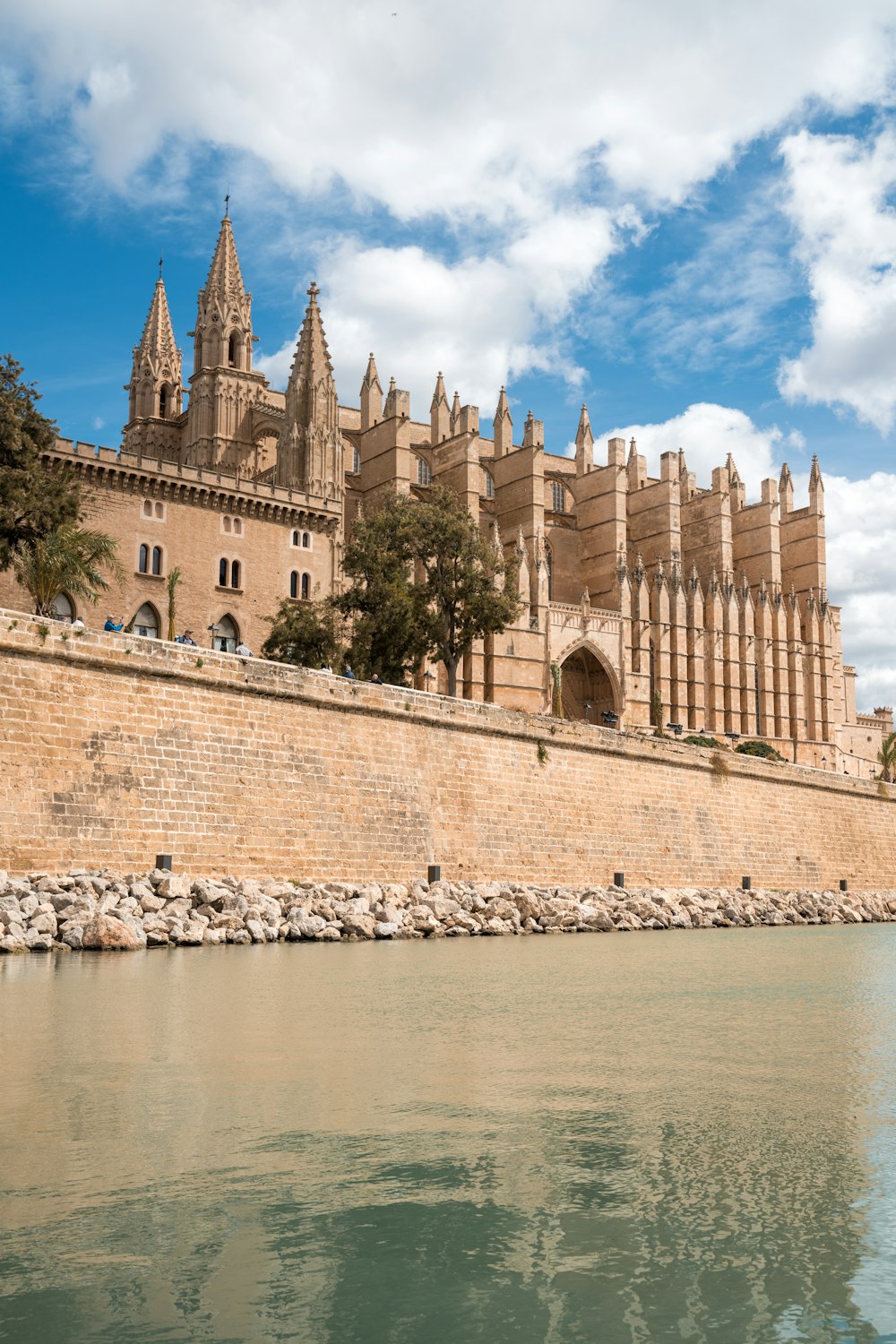 a large building with a clock tower next to a body of water