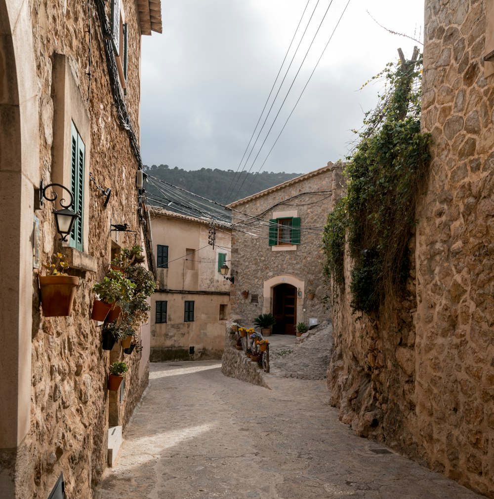 a narrow alley with stone buildings and green shutters