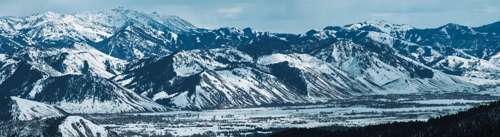 a view of a snowy mountain range in the mountains