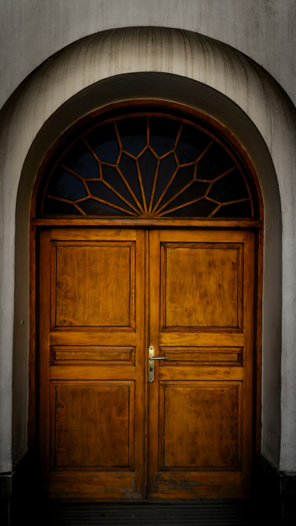 a large wooden door with a window above it