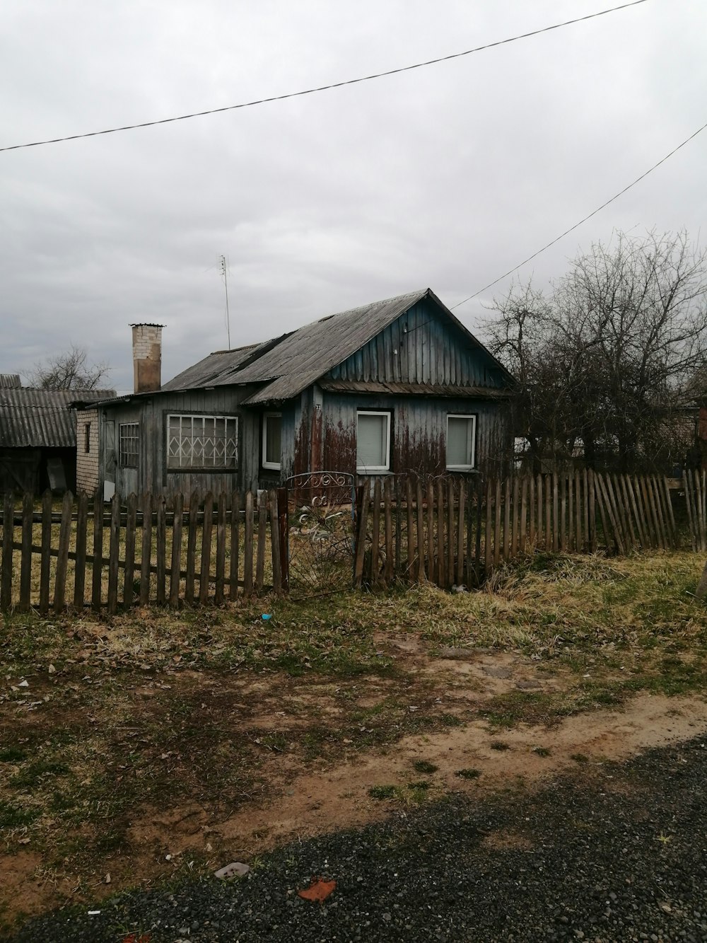 an old house with a wooden fence in front of it