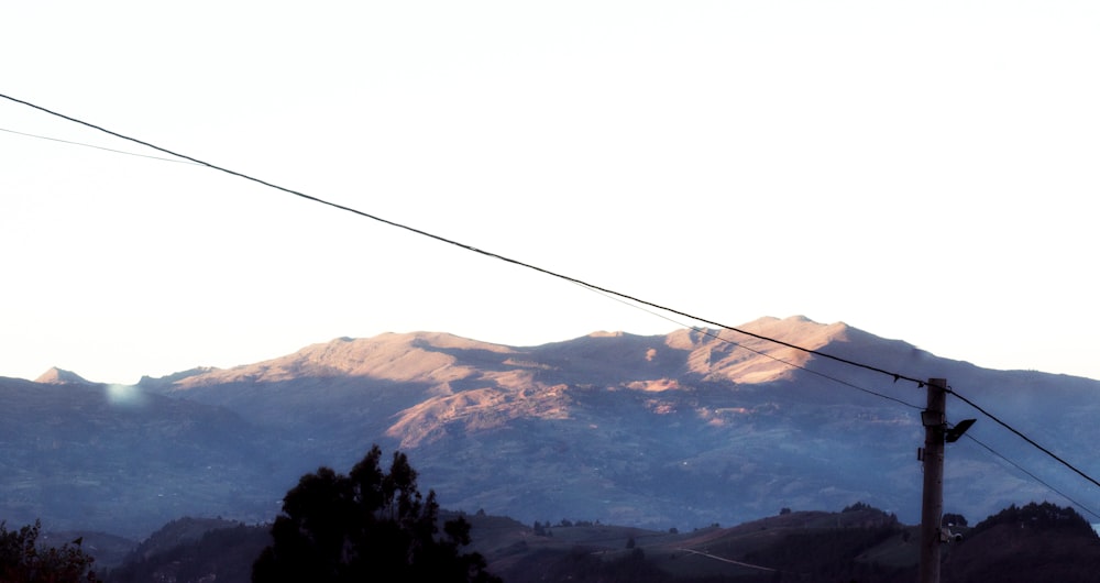 a view of a mountain range with power lines in the foreground